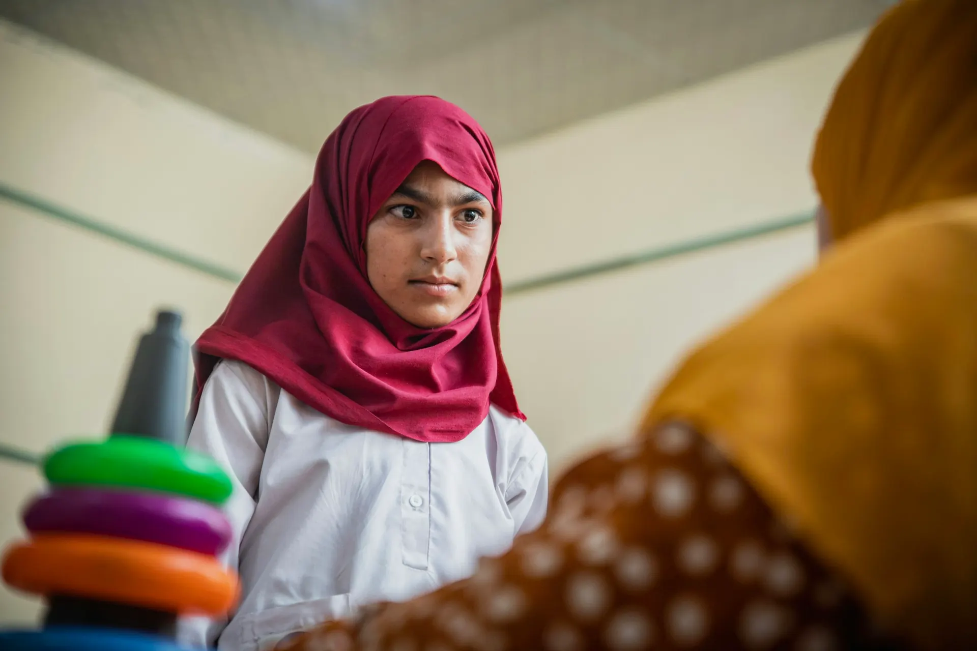 Student in a red headscarf during a classroom activity