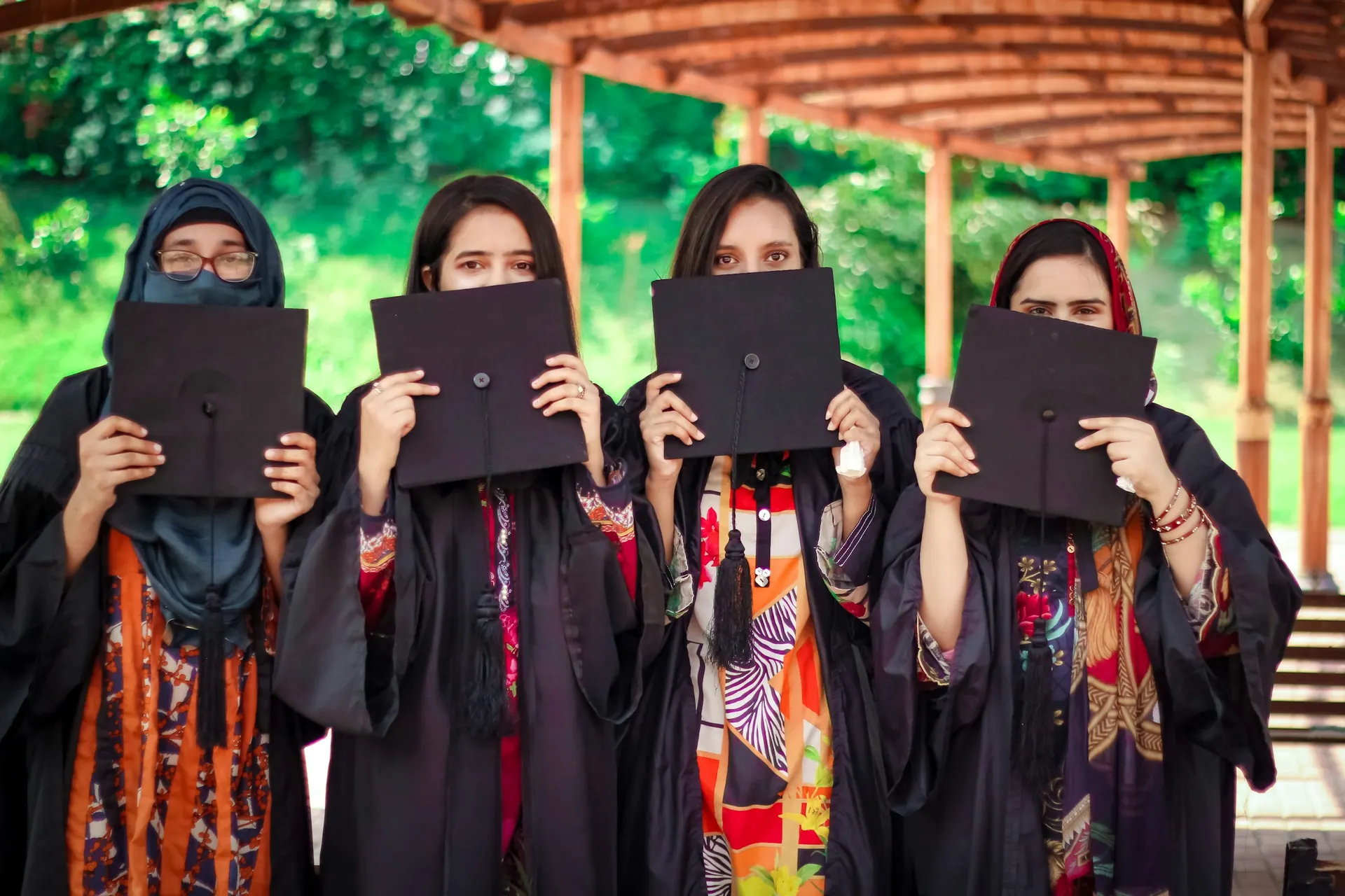 Graduates in gowns holding their caps