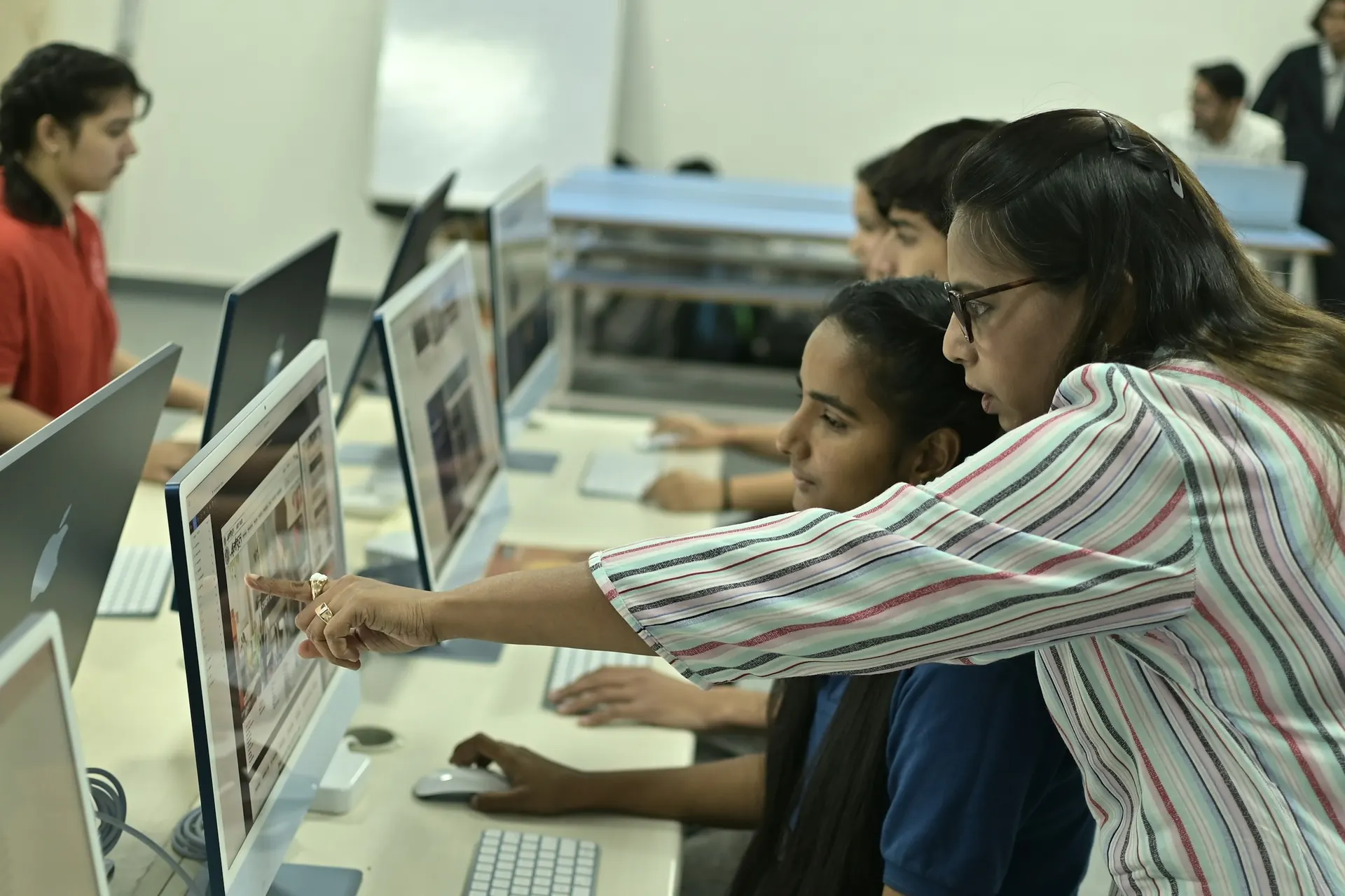 Teacher guiding a student through a lesson on the computer
